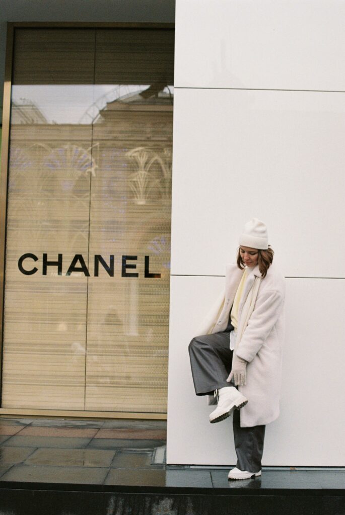 Stylish woman in winter clothes next to Chanel store, Moscow.