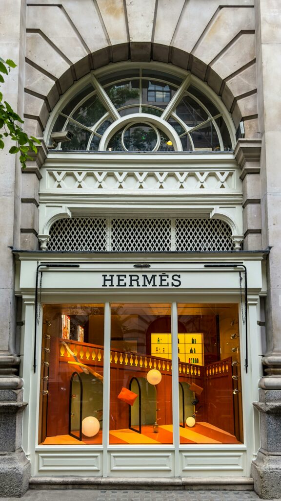 Elegant Hermes store display showcasing luxury fashion in a classic urban setting.